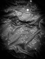Black polo shirt featuring a minimalist all over print coilover suspension graphic 