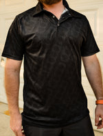 Black business casual polo shirt featuring a subtle, all-over repeating pattern of a 4-cylinder engine head gasket.